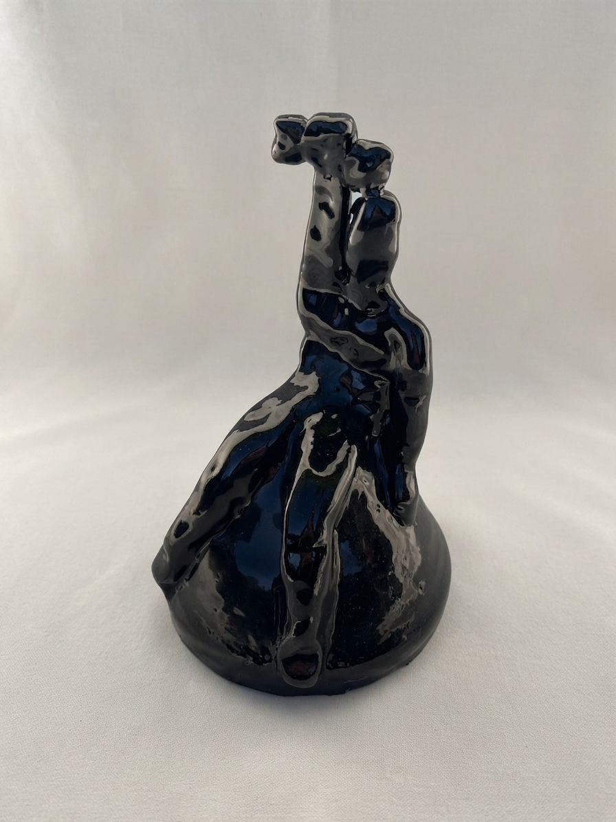 Figura de cerámica negra azulada con un brazo levantado y la cabeza hacia atrás